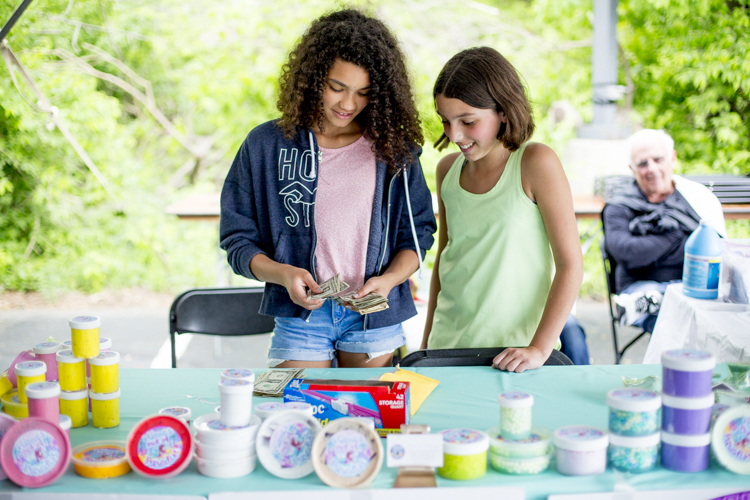 Caylin Brandon and Lila Barron count money from their slime sales.