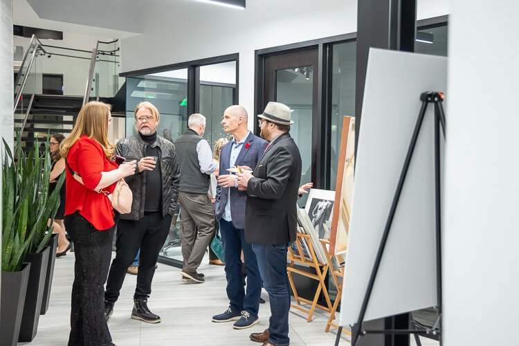 The artist Erik Nordin, second from right, speaks with guests.