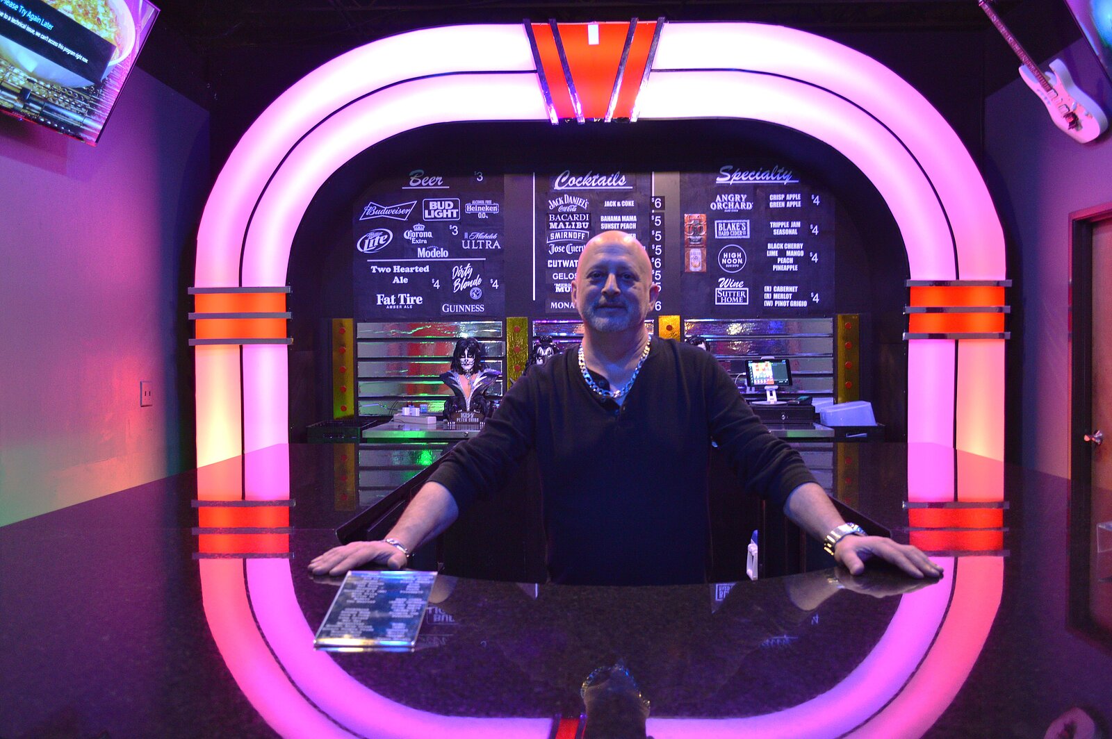 JOE KOLIBA: Joe Koliba, owner of Free Play Pinball Arcade standing behind the jukebox bar. Credit: Genevieve Fox. 
