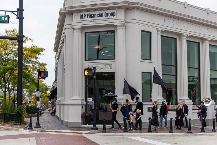 Parading past the historic Farmington State Savings Bank building, renovated by, and now headquarters to, Grand Raven sponsor GLP Financial Group.