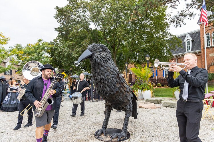 Brass Animals and the crowd rally around Edgar the Grand Raven in front of downtown's historic Masonic Hall.