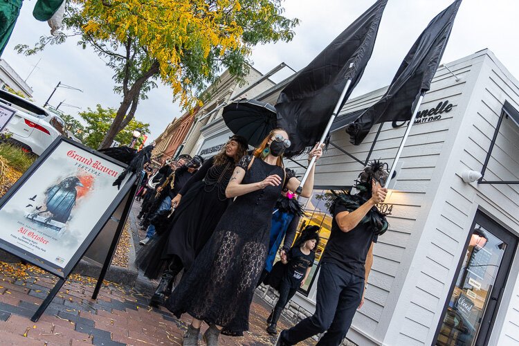 Revelers march along Grand River Avenue past the newly-opened and much buzzed about Cannelle Patisserie.