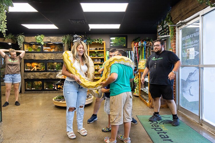 A snake hangs around with some visitors at the Reptarium.