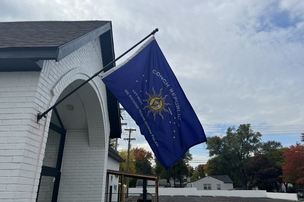 A Key West flag flying outside of Eastern Palace Club.