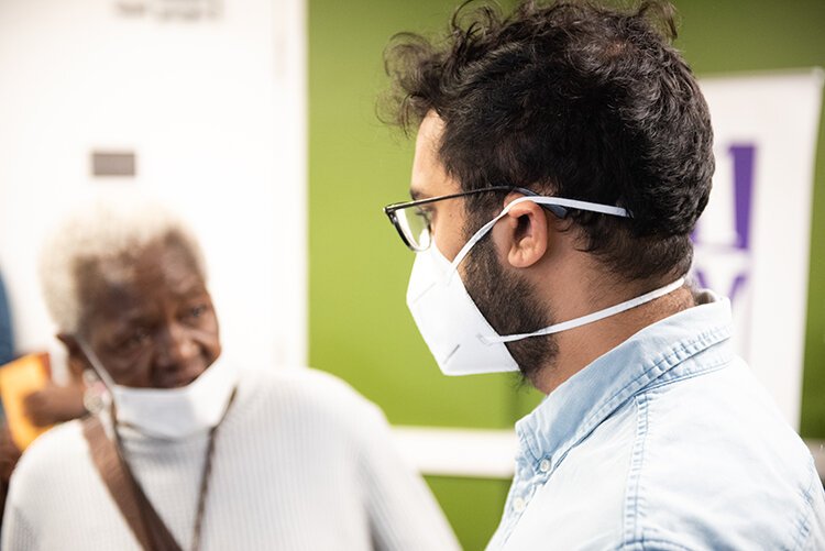 Shiraz Ahmed talking to a member at City Covenant Church about their health care situation. Photo: Kahn Santori Davison. 
