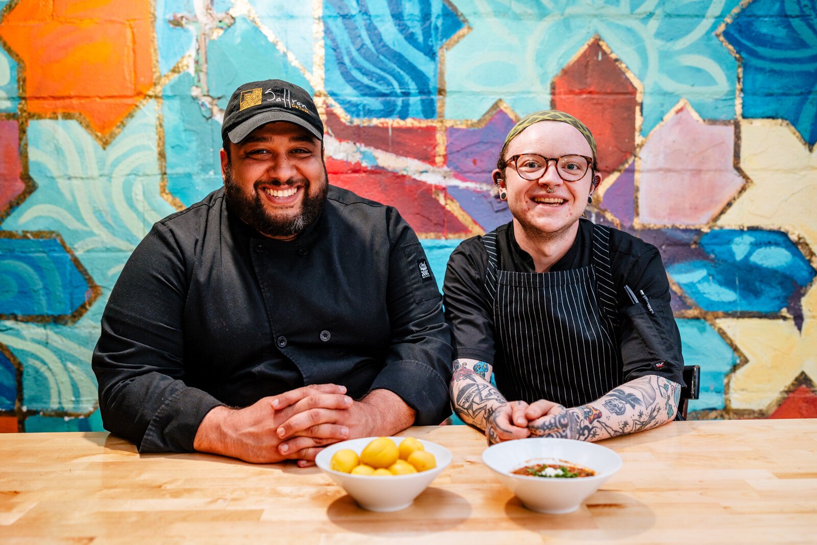 From left, Chef Omar Anani and Artemis McGettigan pose at a table in Saffron De Twah.