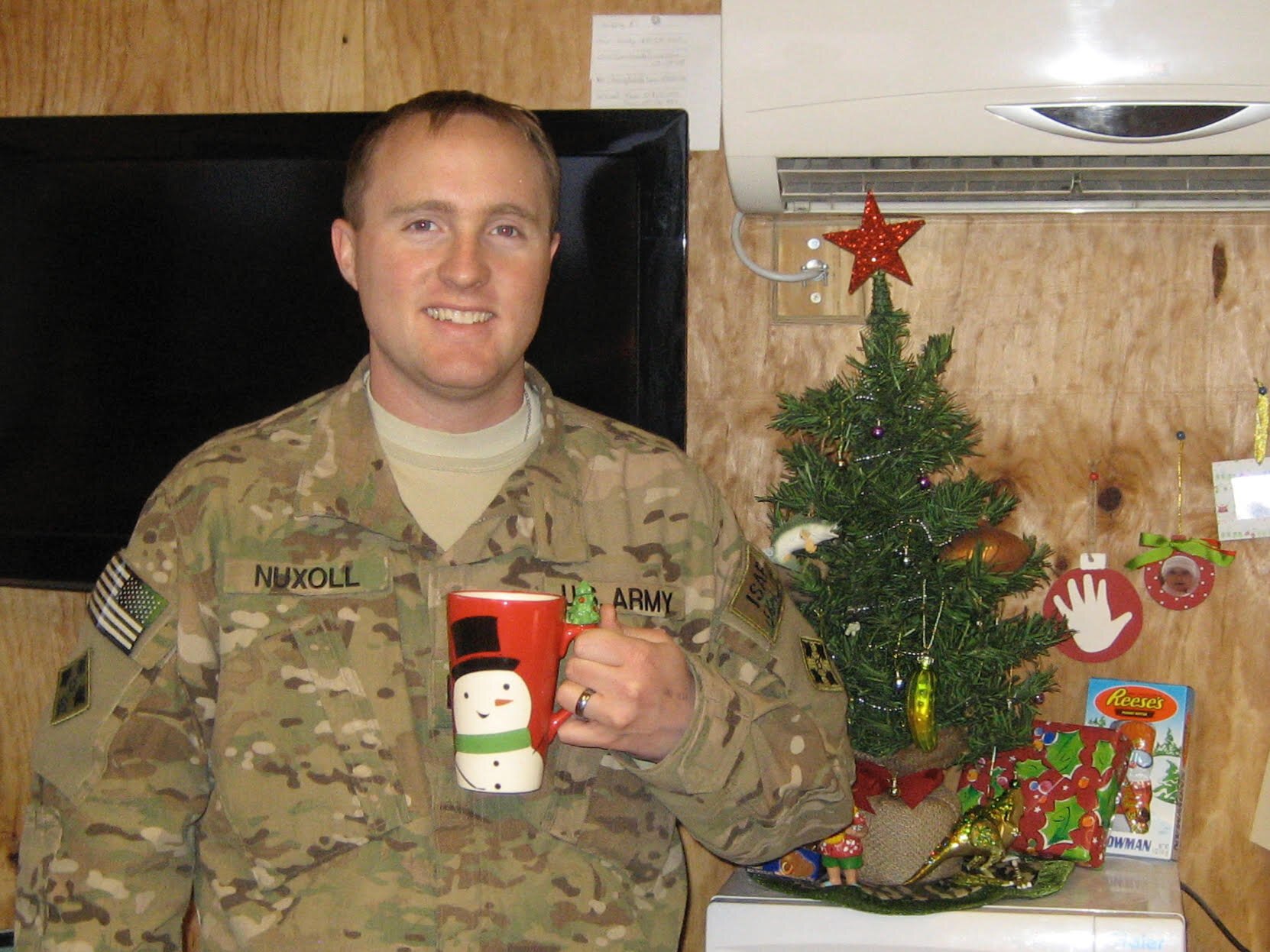 Samuel Nuxoll poses at Camp Nathan Smith in Kandahar City, Afghanistan, to thank his wife for a Christmas care package she sent.