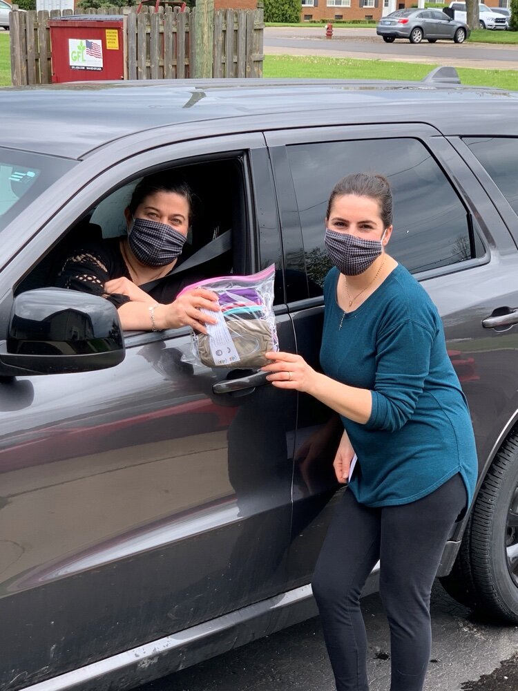 CCF behavioral health manager Susan Kattula purchases clear masks from seamstress Klodia Gossiaux. (Photo courtesy of CCF)
