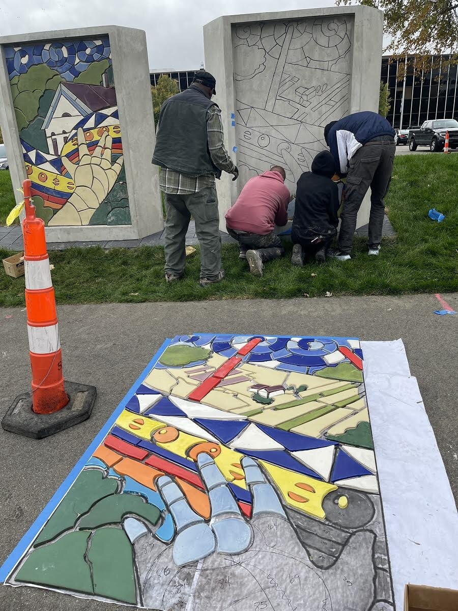 Muralist Hubert Massey and a crew of artists work on a mural along the city of Southfield's shared-use hiking and biking path along southbound Northwestern Highway on the campus of Lawrence Technological University.