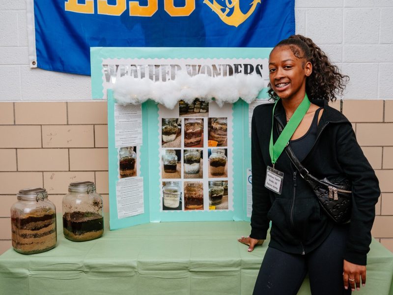 Supplemental Science student Madison Taylor with her exhibit on soil samples at a science fair at WAY Academy in Detroit.