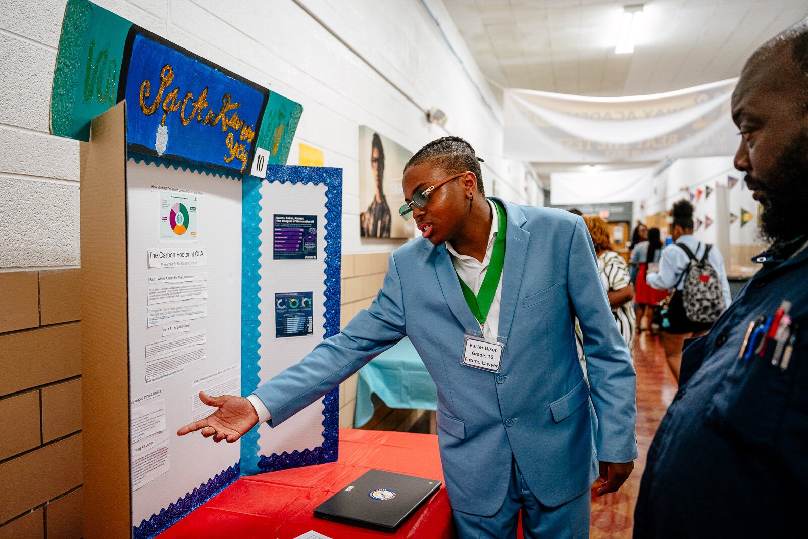 Supplemental Science student Karter Dixon shows off his exhibit about the impacts of artificial intelligence during a science fair at WAY Academy.