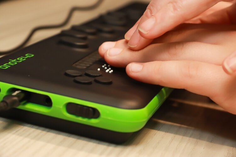 A child learns how to use a braille reader.