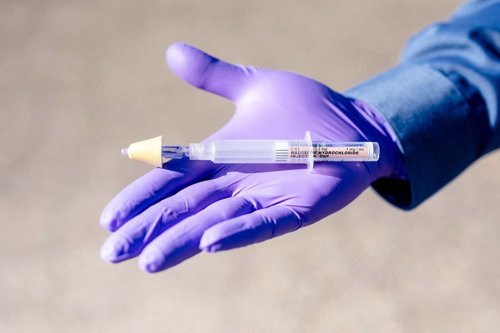 Karl Rock holds a syringe of naloxone.