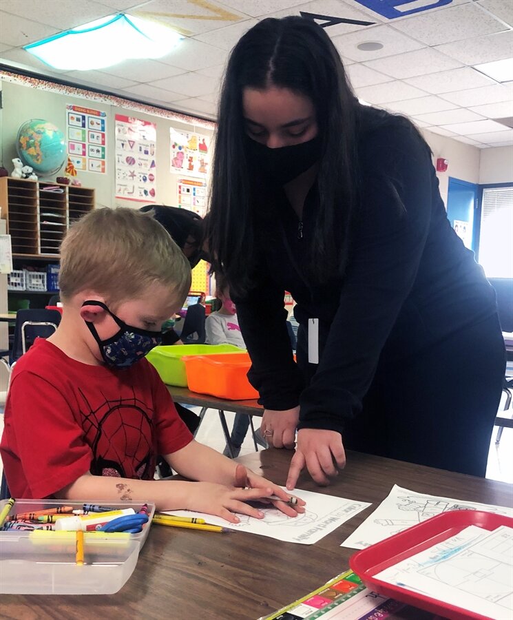 Henry Ford II senior Trezeta Halaq, pictured here with a Graebner Kindergarten student, plans to enroll next year in Oakland University's elementary education program.
